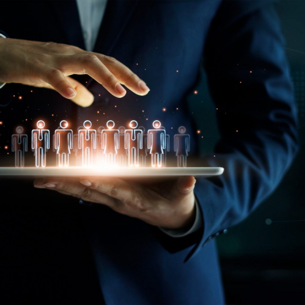 Businessman holding tablet and management group of people in his hand. Virtual icon of social network. Business technology concept.